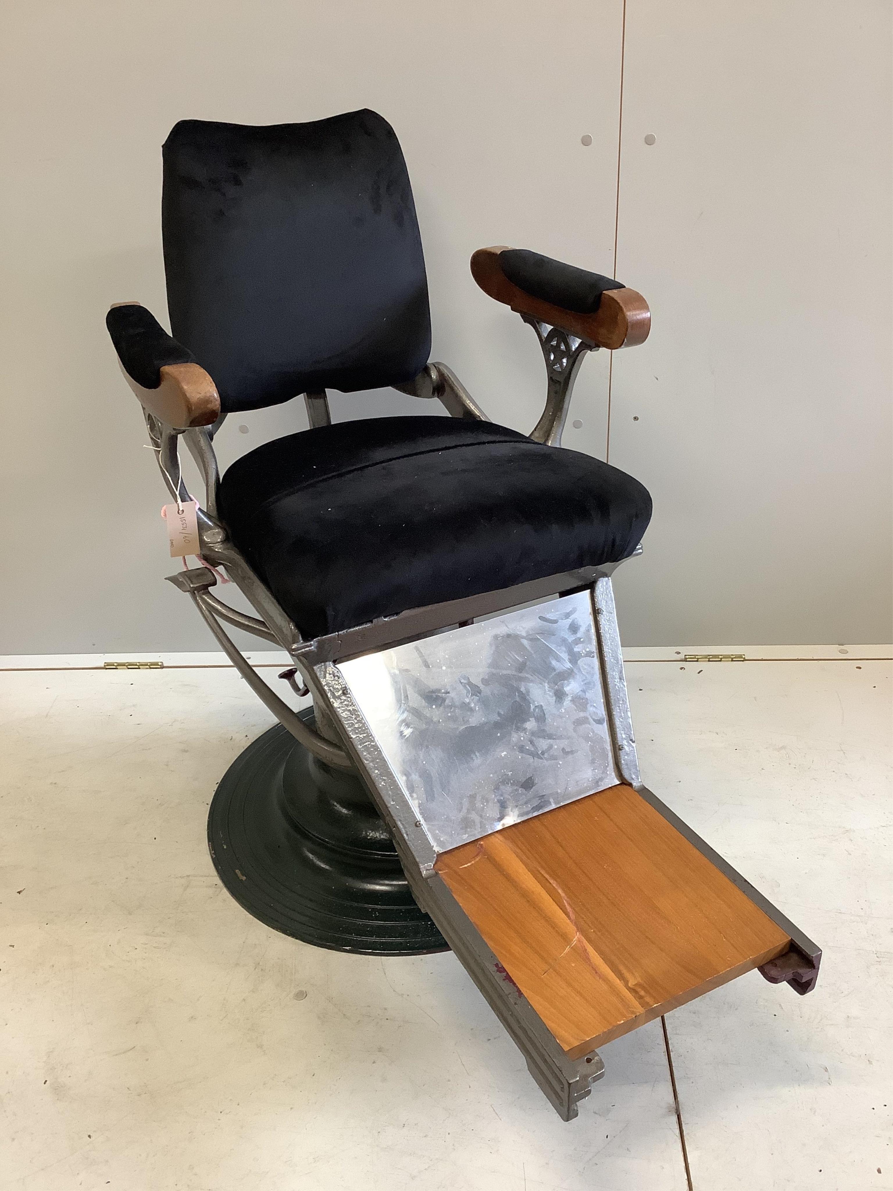 A pair of heavy cast iron upholstered and teak barber's chairs. Condition - fair to good, one with loose arms